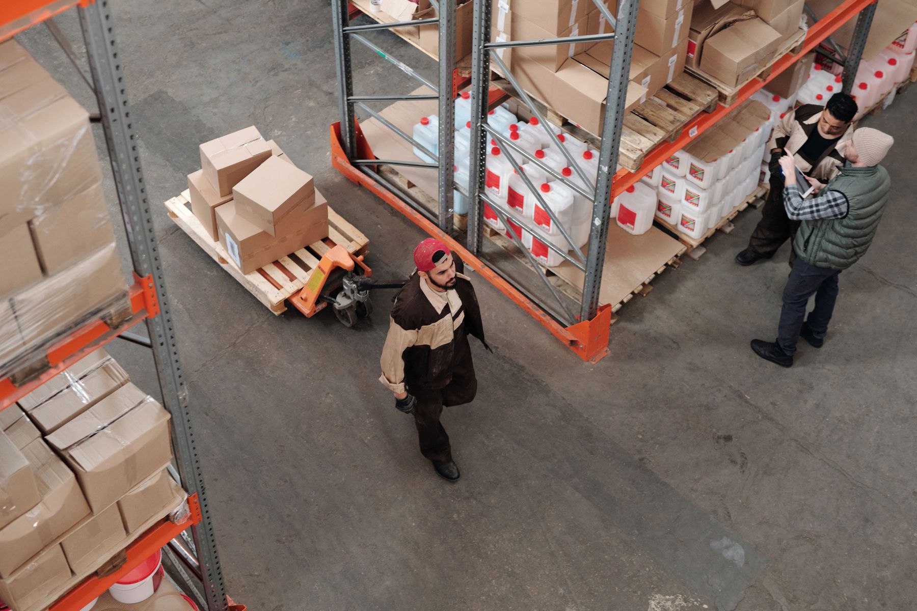 Overhead view of warehouse staff, cartons and a pallet jack