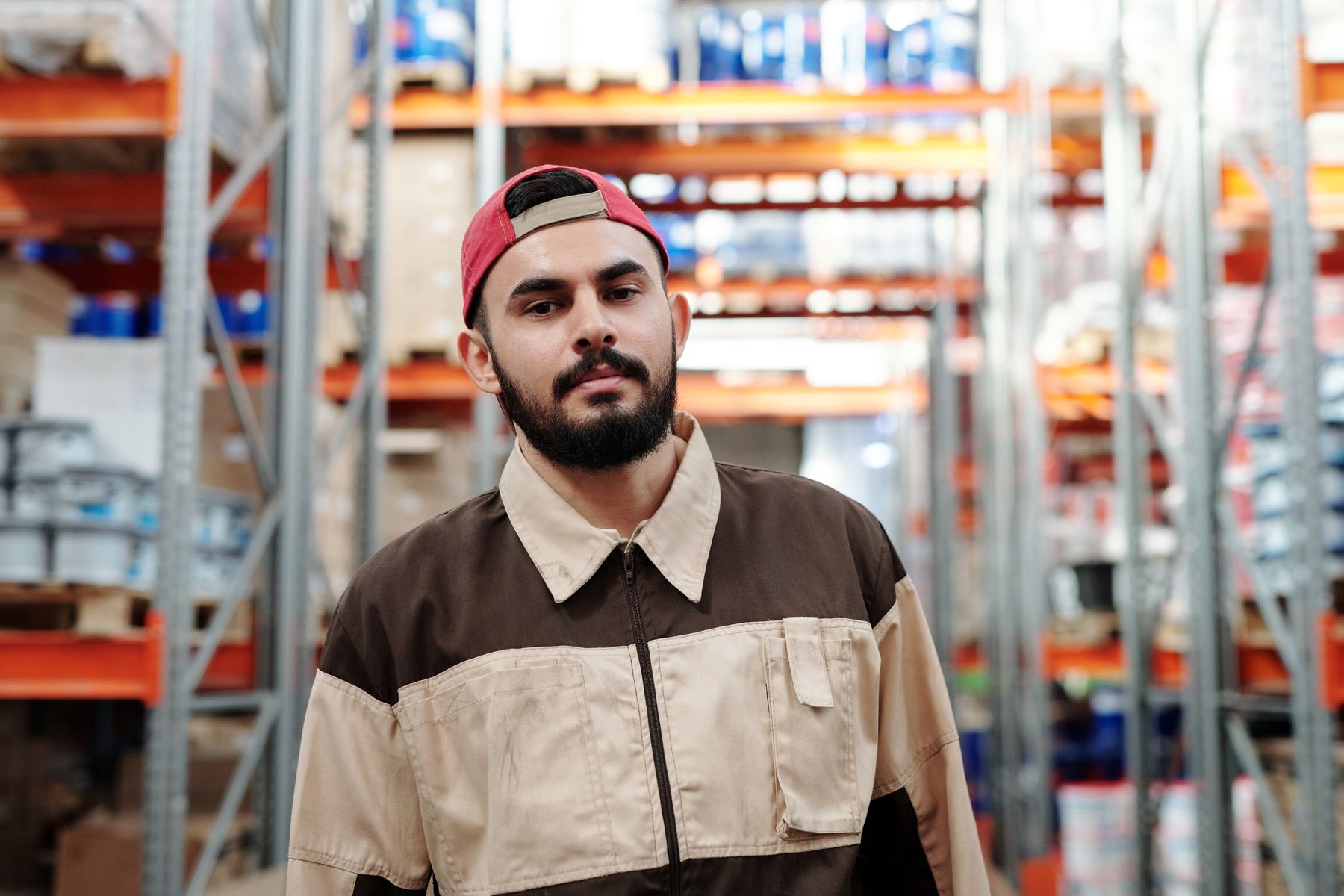 Warehouse worker standing in an aisle between storage racks